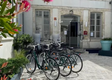 La cour de l'entrée de l'hôtel, 3 vélos sont garés devant.