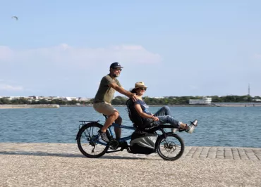 2 personnes sur un tandem en bord de mer