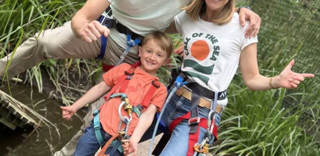Parents et leur enfant à l'accrobranche